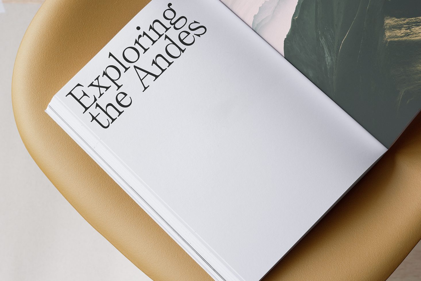 Elegant magazine mockup on a tan leather chair, showcasing a customizable cover with 'Exploring the Andes' title for design presentation.